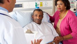 Doctor Talking To Senior Couple On Ward